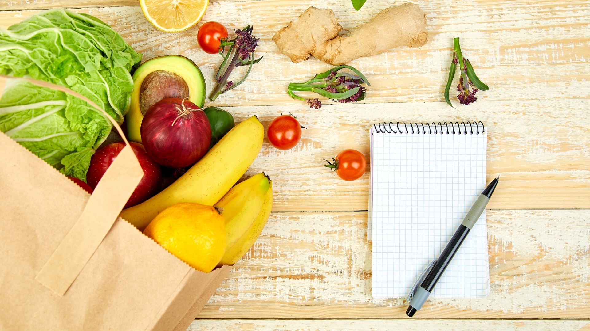 Frisches Obst und Gemüse mit Notizblock und Stift auf einem Holztisch - gesunde Zutaten für eine natürliche Ernährung als Gottes Nahrung.