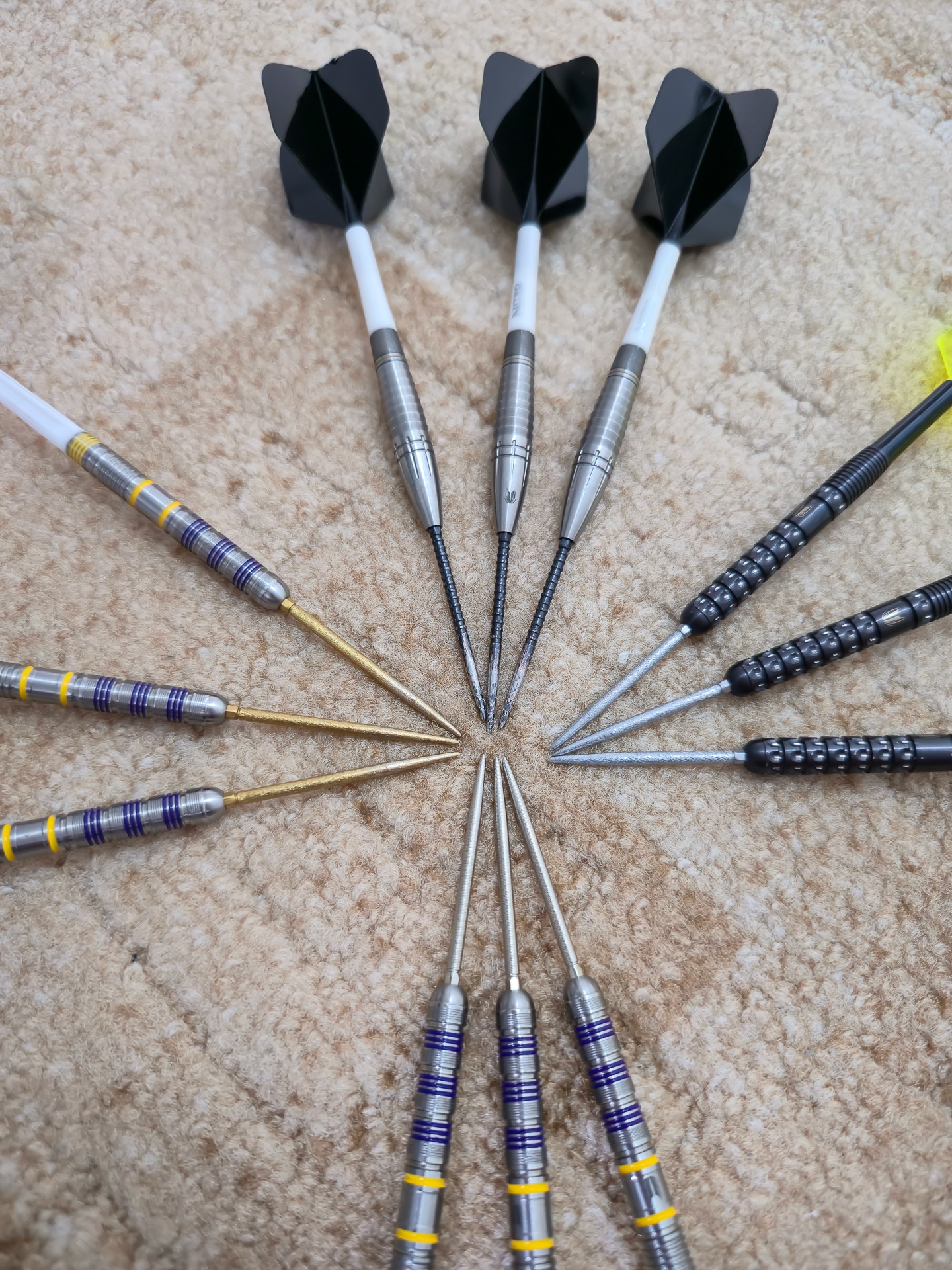 Fächeranordnung mehrerer Darts mit Gold, Schwarz und Silber Swiss Point Spitzen – Fokus auf Tip-Form