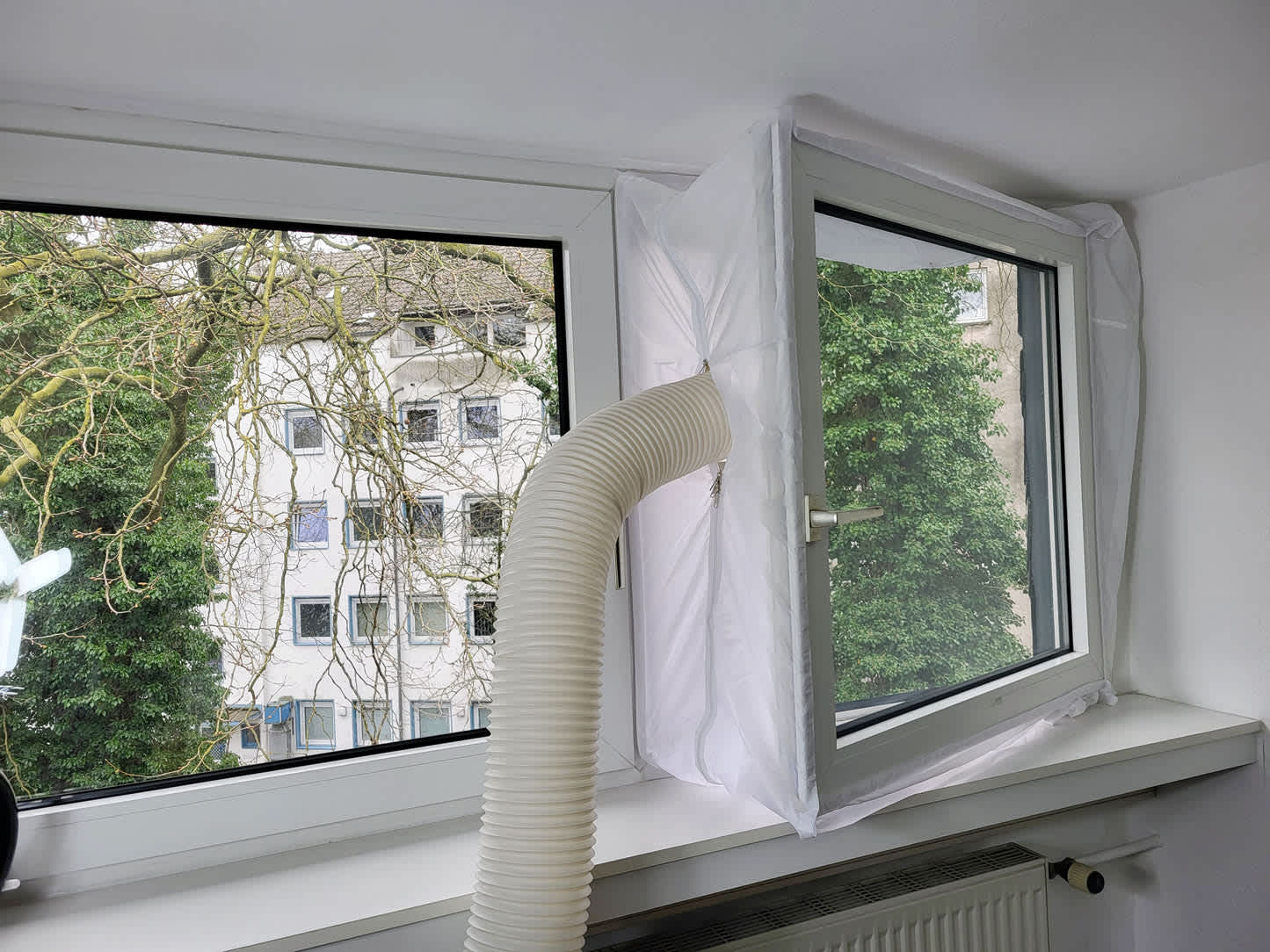 Abluftschlauch einer mobilen Klimaanlage unter 300 Euro mit Fensterabdichtung in einer Wohnung installiert.