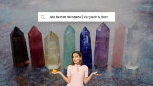 Frau vergleicht Citrin und Hämatit vor Reihe bunter Kristall­säulen – Heilsteine Vergleich & Test 2025
