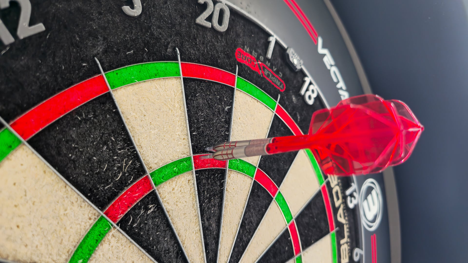 Die Nathan Aspinall Gen 2 Darts stecken alle perfekt im Triple-20-Feld einer klassischen Dartscheibe.
