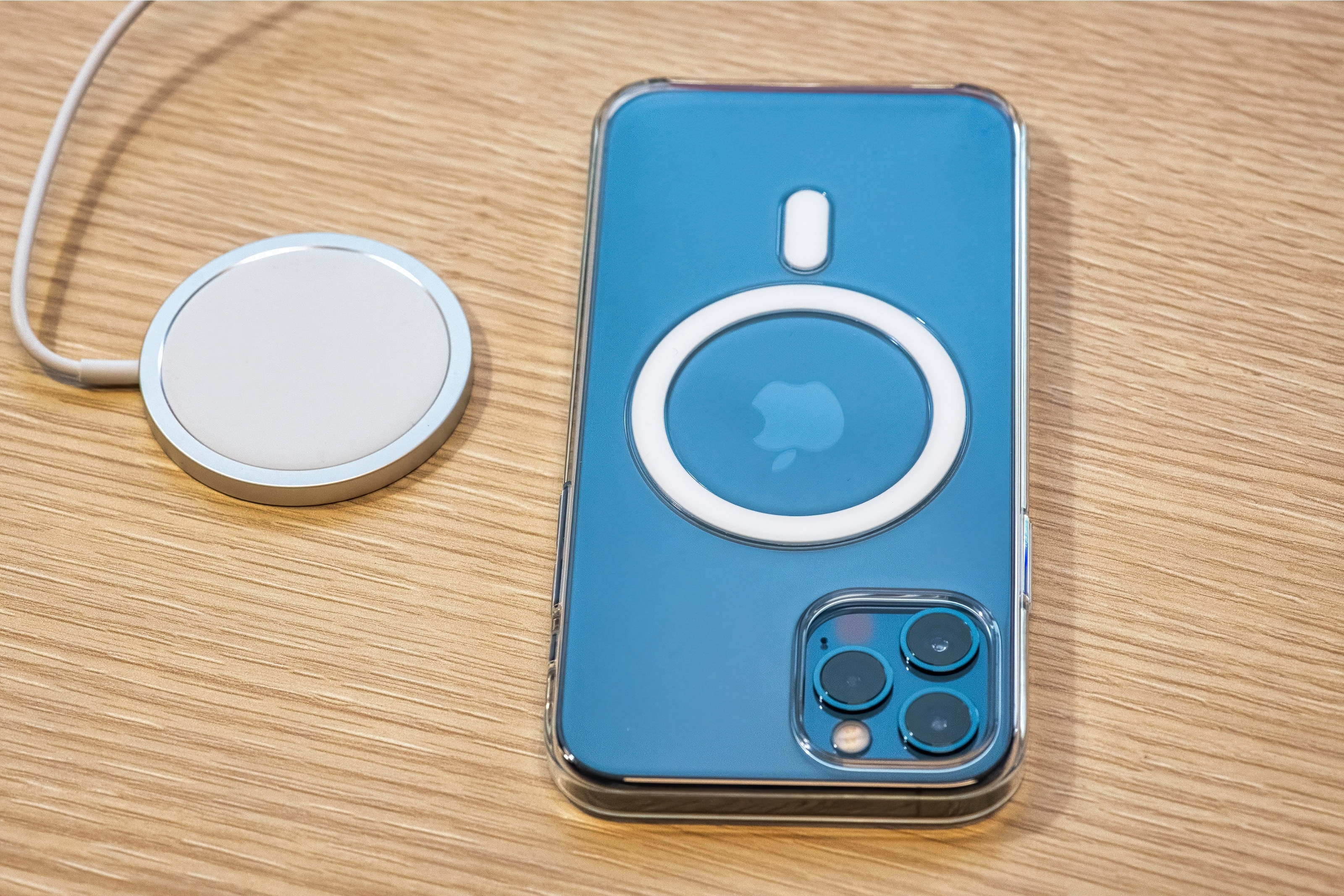 MagSafe-Ladeplattform und iPhone mit Magnetring-Hülle auf Holzoberfläche