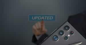 Hand tippt auf einen schwebenden „UPDATED“-Schriftzug; daneben die Rückseite eines Samsung-Smartphones mit Mehrfachkamera und S Pen – Symbolbild für ein Software-Update.
