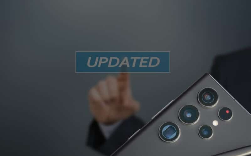 Hand tippt auf einen schwebenden „UPDATED“-Schriftzug; daneben die Rückseite eines Samsung-Smartphones mit Mehrfachkamera und S Pen – Symbolbild für ein Software-Update.